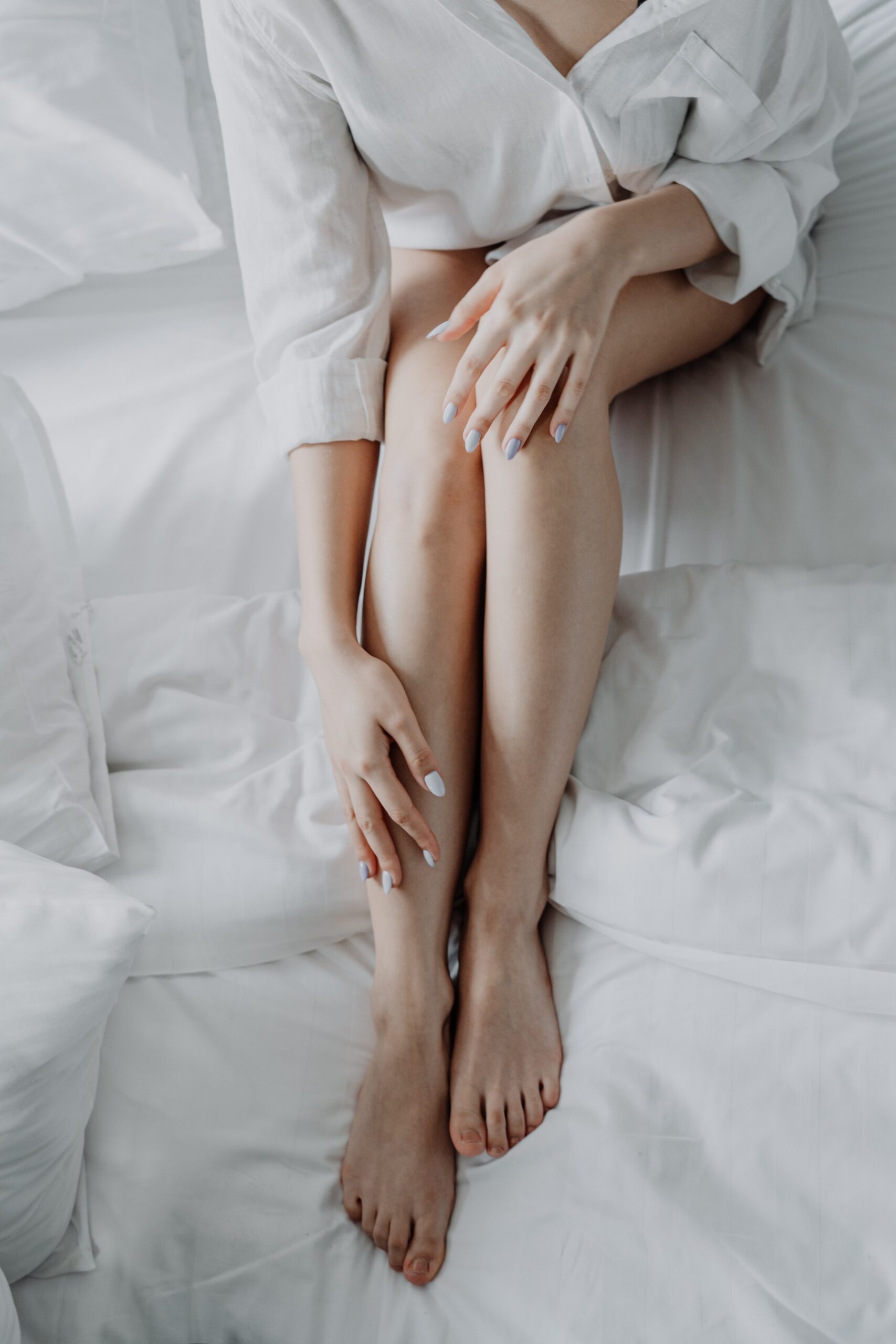 woman in bed with with nice legs free of spider and varicose veins about microphlebectomy